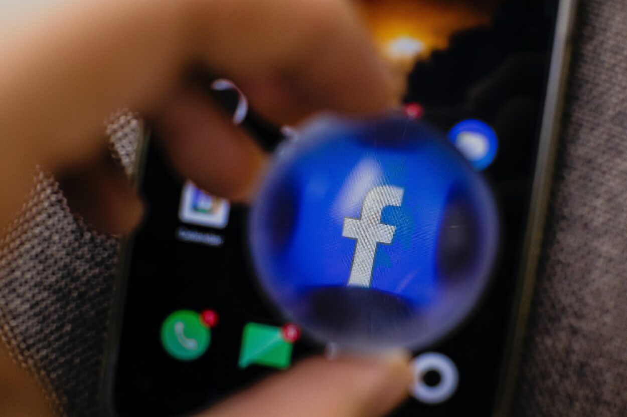 Facebook app icon on a phone magnified with a round glass