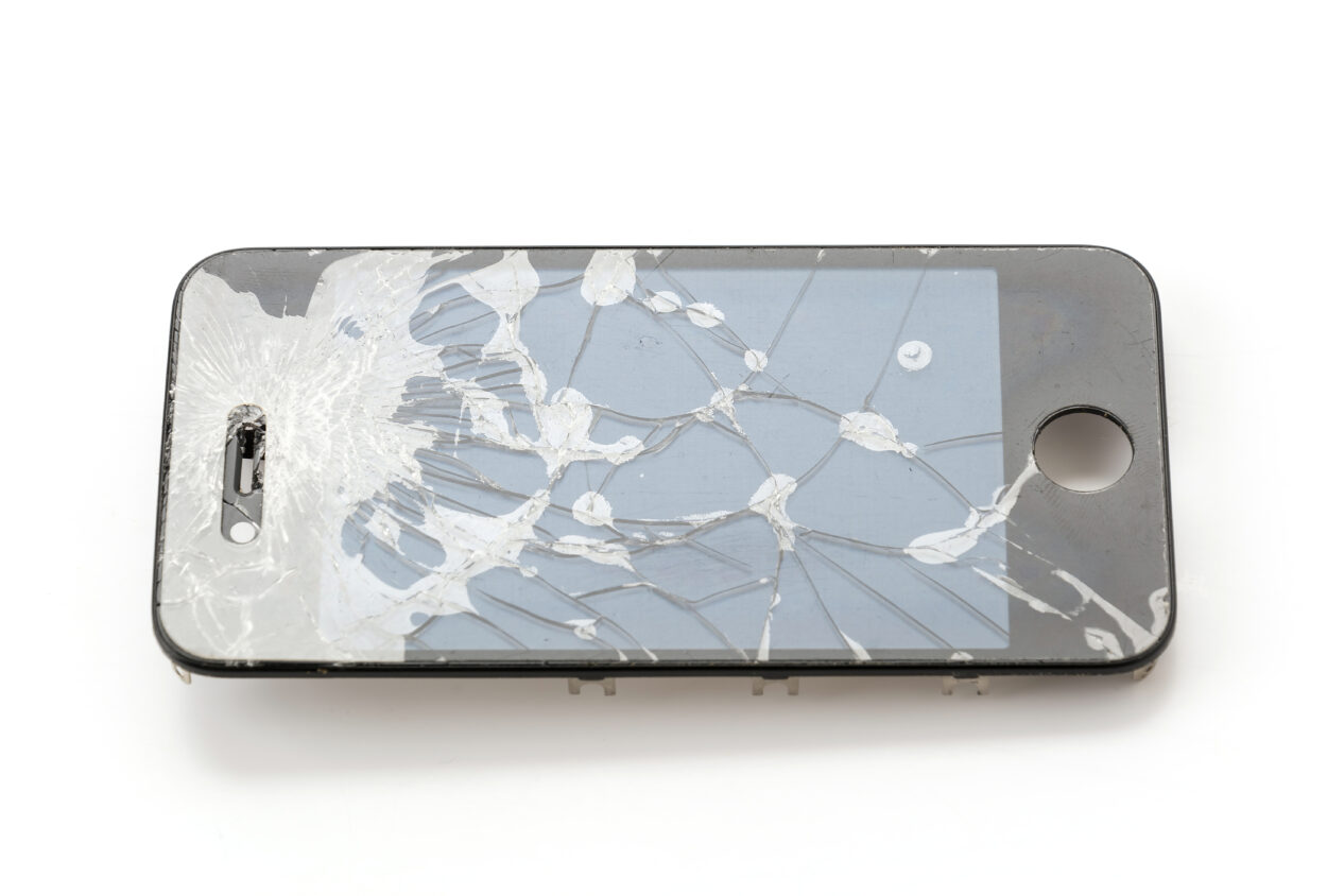 A broken old iPhone on a white background