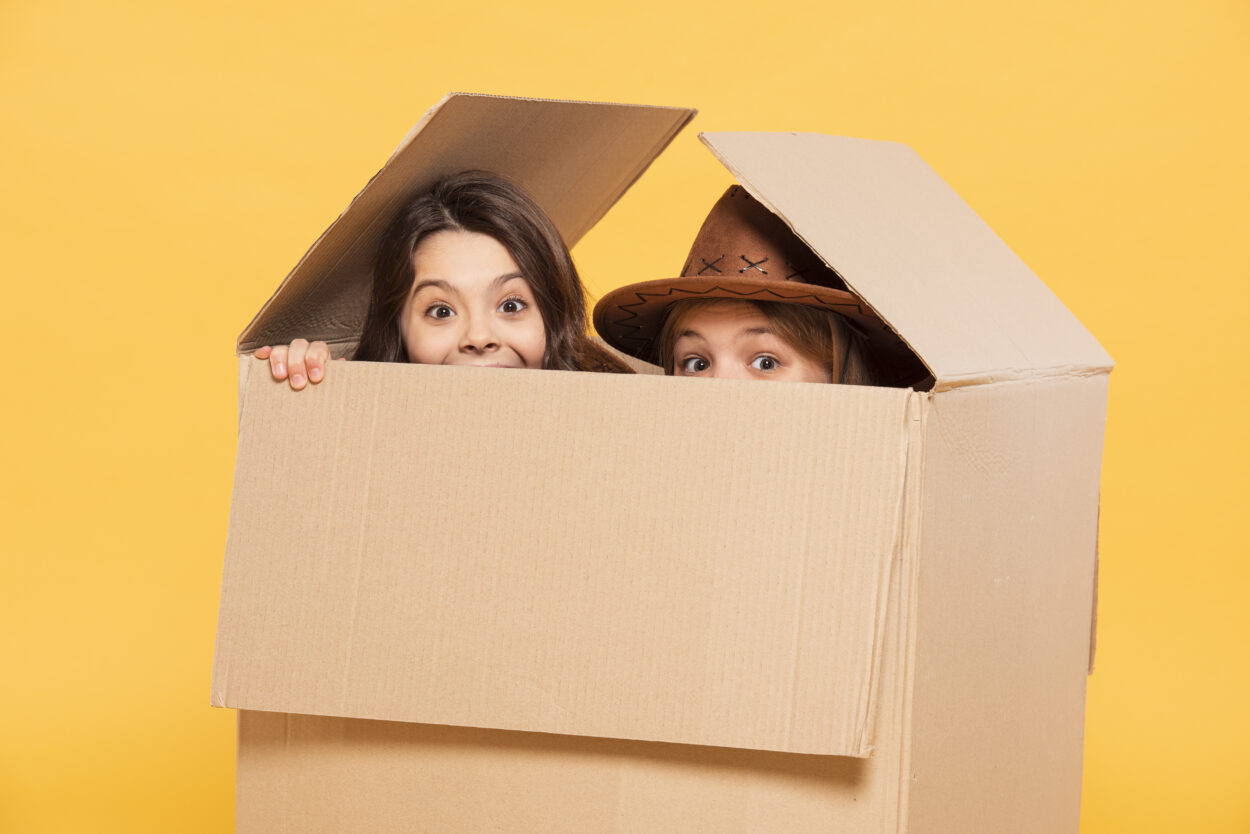 2 girls hiding in a box