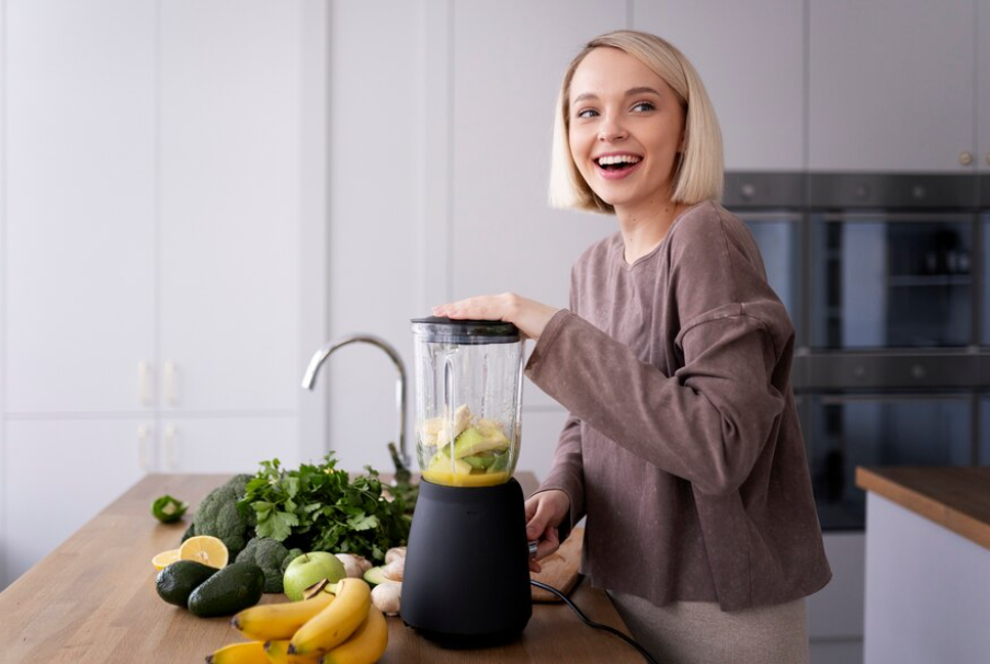 A happy woman blending some fruits