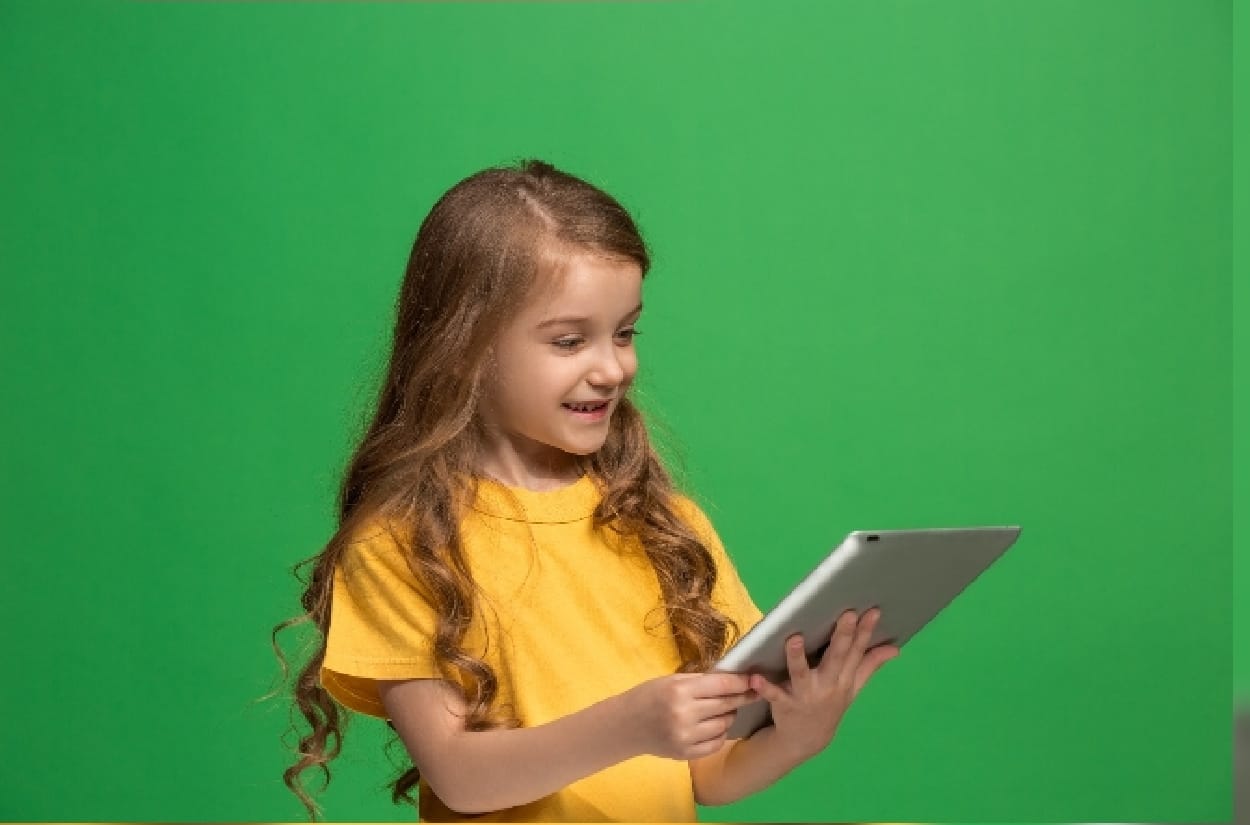 A kid using a silver tablet
